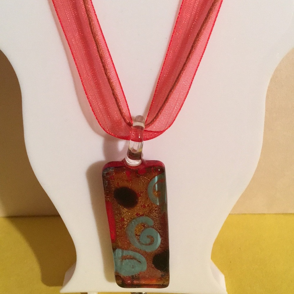 Red ribbon/string necklace with glass pendant.